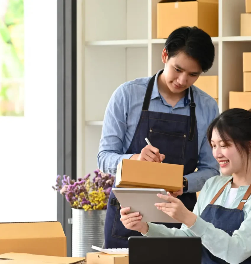 Start up business people working in modern home office and prepa Start Up Business People Working In Modern Home Office And Preparing Parcel For Delivery. Online Selling, E-Commerce Concept.